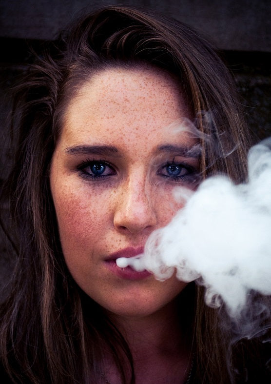 girl blowing smoke from vape